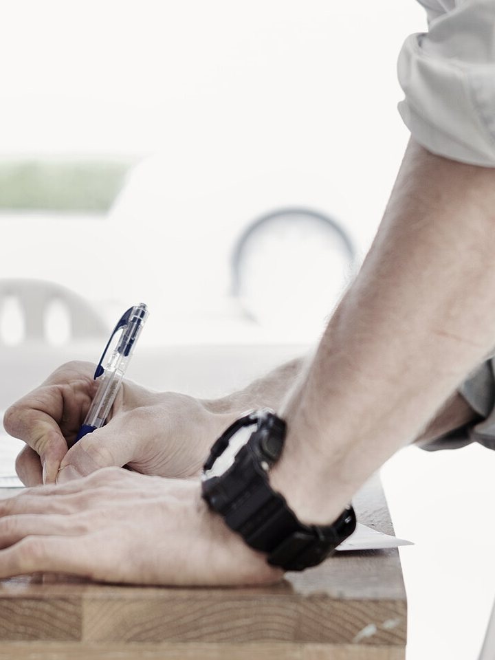 A rep marking up a printed quote by hand.